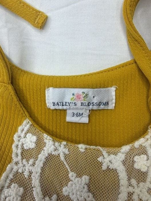 Bailey’s Blossoms mustard yellow ribbed knit romper with lace detail