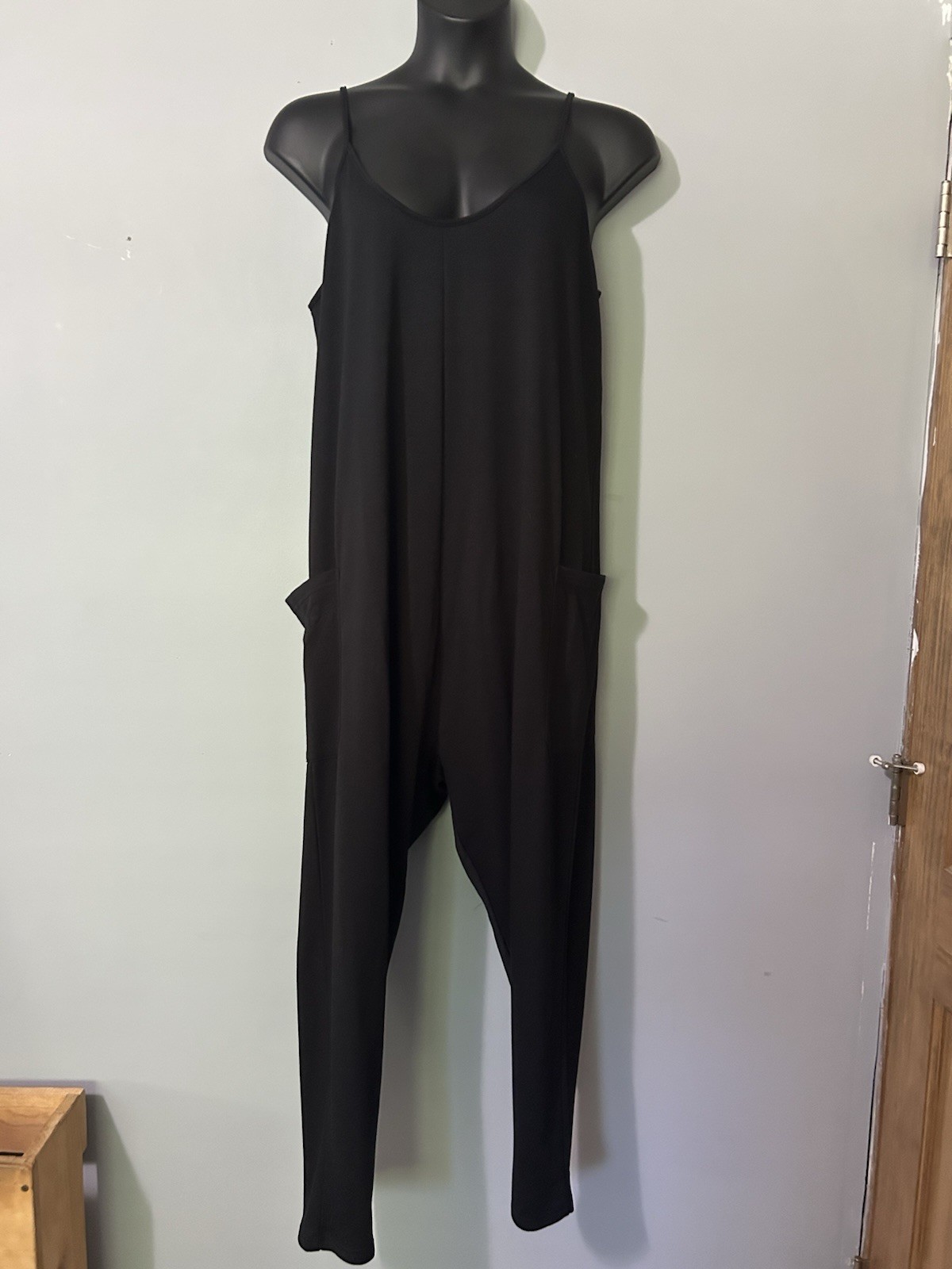 Black jumpsuit features a v-neckline and functional side pockets. Sz 1xl